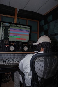 a man sitting in front of a computer in a recording studio